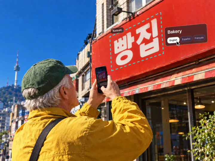 Man photographing a Korean bakery sign in Seoul, the sign translated with English, Spanish and French options